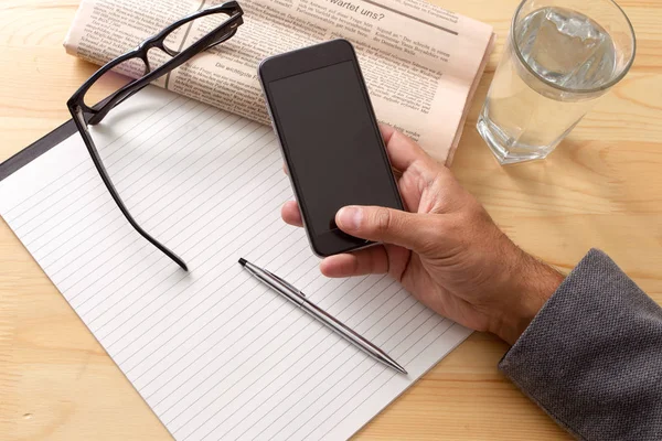 Kopp kaffe tidningen händer mobiltelefon — Stockfoto