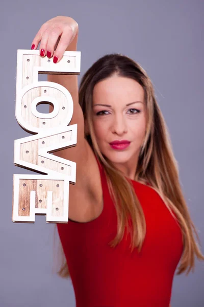 Vrouw dragen rode jurk bedrijf teken liefde symbool — Stockfoto