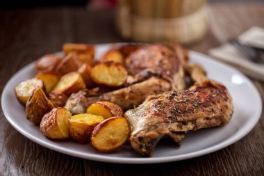 Roast chicken with potatoes on a plate clipart