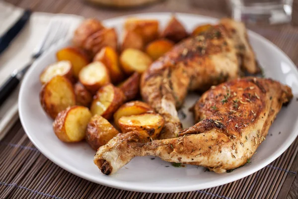 Pollo asado con patatas en un plato —  Fotos de Stock