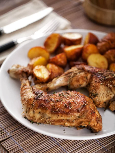Жареная курица с картошкой на тарелке — стоковое фото