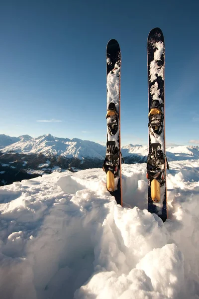 Skis dans la neige dans les montagnes — Photo