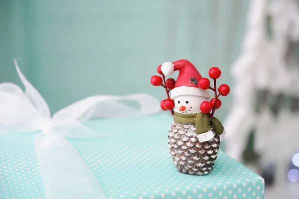 Toy snowman on on turquoise background, Christmas gifts — Stock Photo, Image