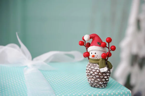 Toy snowman on on turquoise background, Christmas gifts — Stock Photo, Image