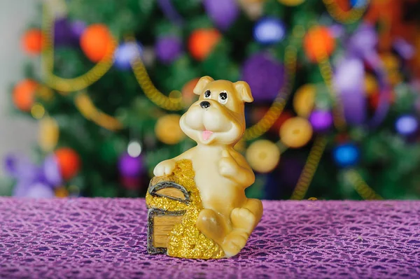 Toy dog on the background of Christmas tree — Stock Photo, Image