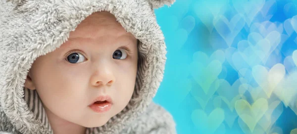 Closeup of beautiful happy baby on blue heart shaped background — Stock Photo, Image