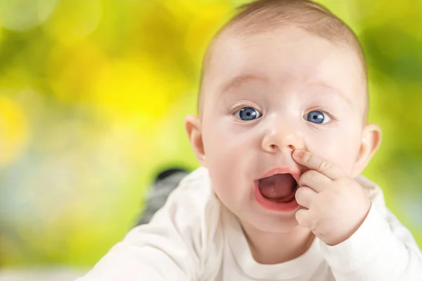 Happy baby on natural green blurred background — Stock Photo, Image