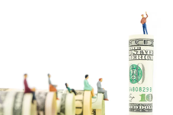 Miniature figurines sitting on the edge of us dollar banknotes — Stock Photo, Image