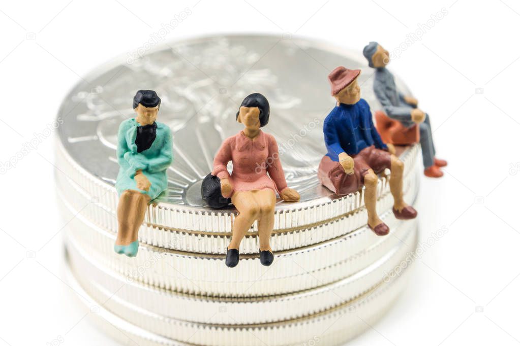 people figurines sitting on silver american eagle coins