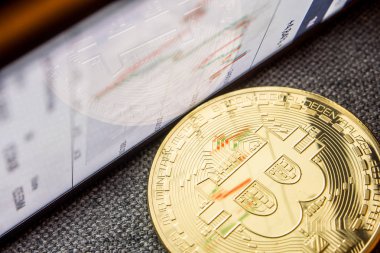 Altın bitcoin para yüzeyinde bir grafik yansıması ile