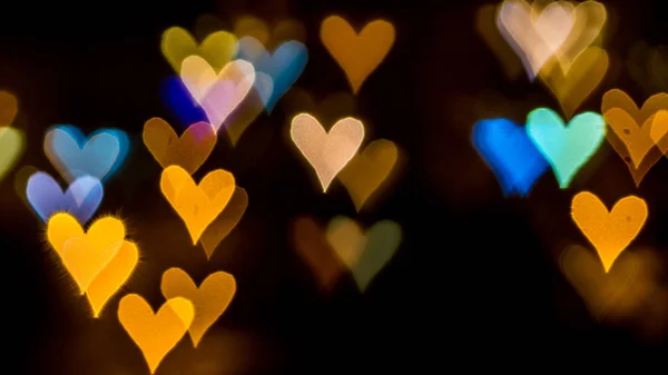 Mehrfarbiges Bokeh von Lichtern in Form eines Herzens auf defokussiertem Hintergrund — Stockfoto