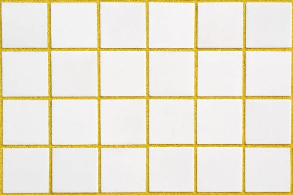 White ceramic tile with 24 squares in rectangular form with golden filling — Stock Photo, Image