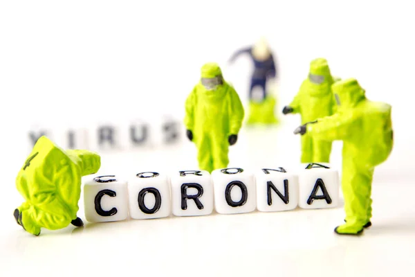 closeup of big corona virus with a team of special medical forces miniature figurines interfering during gas and other chemical accidents, the team preparing for diagnosis and action against very dangerous deadly virus type with the text