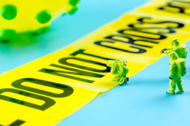 Önünde bekleyen büyük bir virüse yakından bakın. Sınırı aşmayın. Geçit hattını koruyan koruyucu yeşil takım elbiseli özel bir tıbbi tehlike ekibi var.