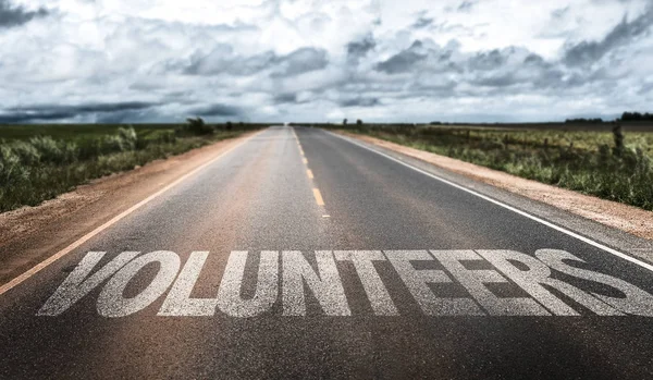 Volunteers sign on road — Stock Photo, Image