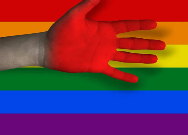 Červená ruka a vlajky gay komunity — Stock fotografie