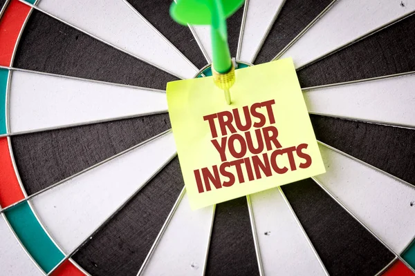 Darts target with inscription trust your instincts — Stock Photo, Image