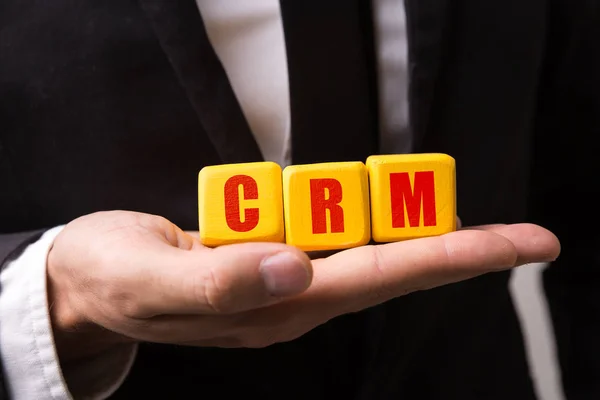 Hand holding a cube with the text: CRM (Customer Relationship Management) — Stock Photo, Image