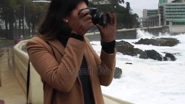 Fiatal felnőtt nő fotós figyelembe képek és képek a viharos tengeren, a Via del Mar, Chile — Stock videók