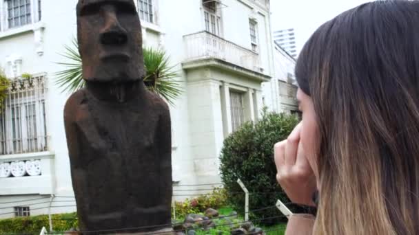 Молодая женщина-фотограф фотографирует статую Моаи на Виа дель Мар, Чили — стоковое видео
