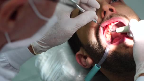Zahnarzt heilt einen männlichen Patienten — Stockvideo