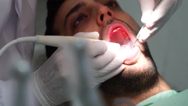 Dentista cura um paciente do sexo masculino — Vídeo de Stock