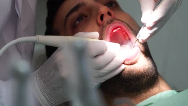 Dentista cura un paziente maschio — Video Stock