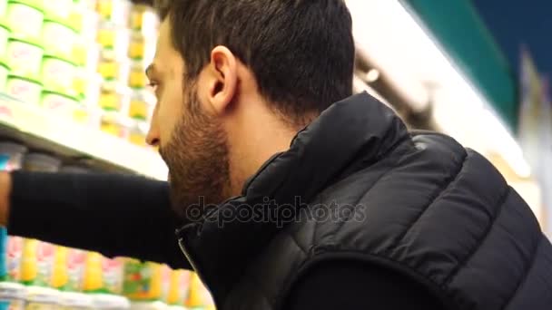 Genç adam süpermarkette alışveriş yapıyor. — Stok video