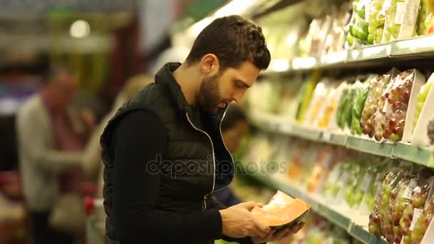 Junger Mann kauft im Supermarkt ein — Stockvideo