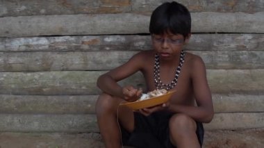 Brezilya'da bir yerli Tupi Guarani kabile içinde geleneksel bir yemek yeme çocuklar
