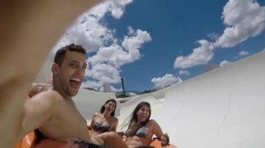 Arkadaşlar eğlenmeye ve aşağı kayan bir su kaydırağı