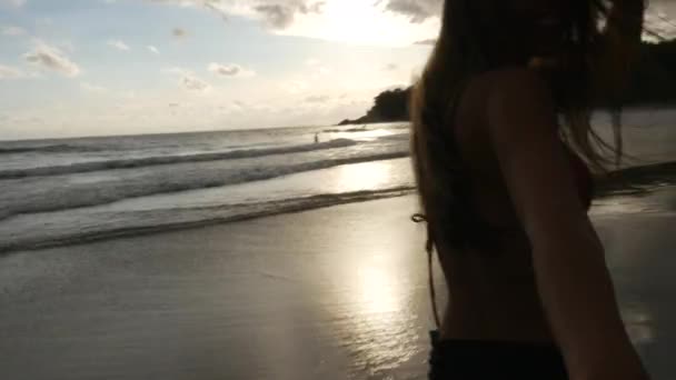 Femme marchant sur la plage romantique tenant la main du petit ami qui la suit - Point de vue 