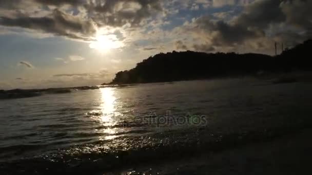 Femme marchant sur la plage de sable au coucher du soleil 