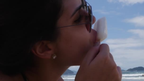 Mooie jonge vrouwen eten ijs op het strand — Stockvideo