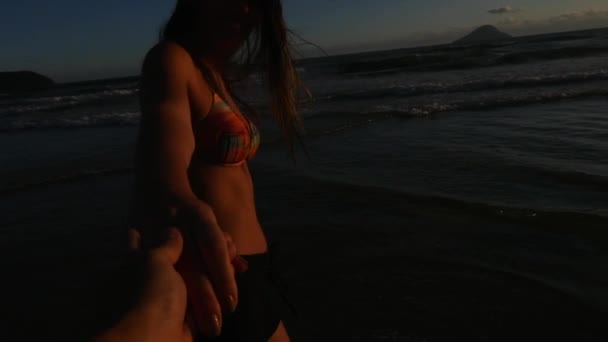 Vue arrière d'un couple qui s'amuse et se tient la main sur la plage - Slow Motion 