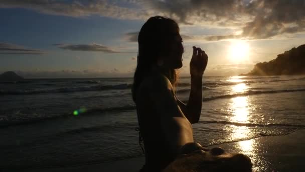 Vista trasera de una pareja divirtiéndose y tomándose de la mano en la playa - Slow Motion — Vídeos de Stock