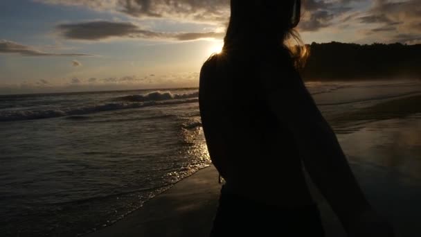 Vue arrière d'un couple qui s'amuse et se tient la main sur la plage - Slow Motion 
