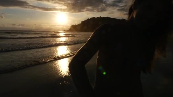 Vista trasera de una pareja divirtiéndose y tomándose de la mano en la playa - Slow Motion — Vídeos de Stock