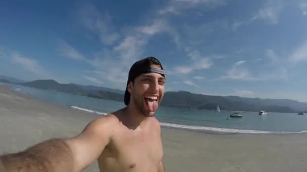 Человек делает селфи и веселится на пляже в Бразилии — стоковое видео