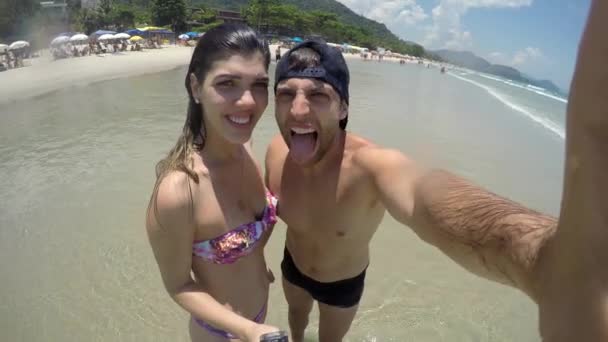 Pareja tomando una selfie y divirtiéndose en una playa en Brasil — Vídeo de stock