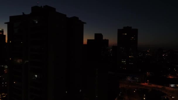 Zonsondergang achter de Skyline van de stad - silhouetten — Stockvideo