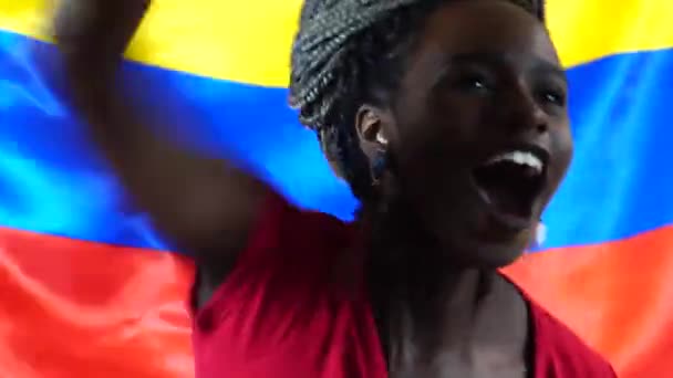 Mulher negra jovem colombiana comemorando com a bandeira da Colômbia — Vídeo de Stock