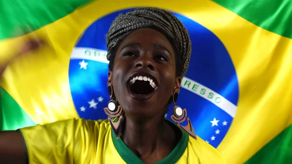 Бразильская молодая чернокожая женщина празднует с флагом Бразилии — стоковое фото