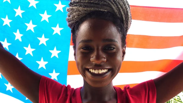 Amerikalı genç kadın ABD bayrağı ile kutlayan siyah