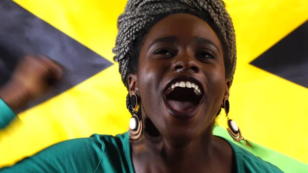 Giamaicano giovane donna nera che celebra con la bandiera giamaicana — Foto Stock