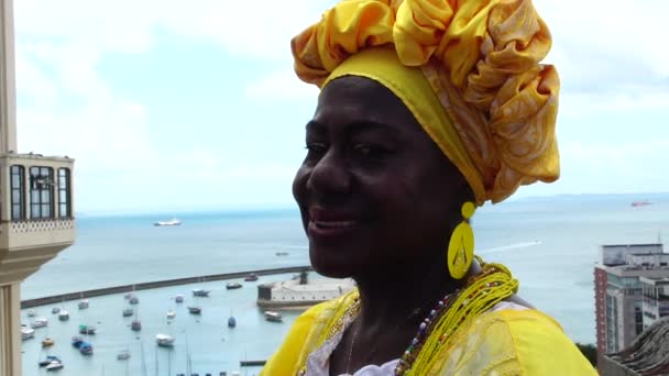 Braziliaanse vrouw van Afrikaanse afkomst, die lacht, gekleed in traditionele Baiana kleding in Lift Lacerda, Salvador, Bahia, Brazilië — Stockvideo