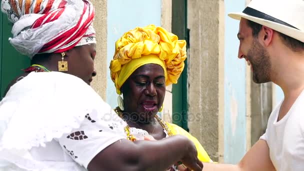 Фанасы приветствуют раздачу "Бразильских ленточек желаний" в бразильском городе Салвадор - ленточки считаются прелестями удачи — стоковое видео