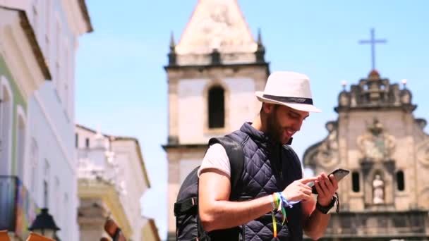 Turista busca un punto de referencia con un navegador GPS en un teléfono inteligente en Salvador, Brasil — Vídeos de Stock