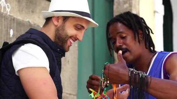 Street Vendor Welcoming Tourist Giving Some Brazilian Ribbons (Fita do Bonfim) on in Salvador, Bahia, Brazil — Stock Video