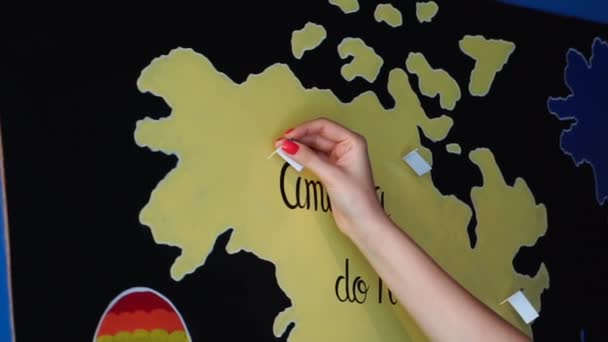 Reisende Frau legt Pin-Position der bereisten Länder auf die Karte — Stockvideo